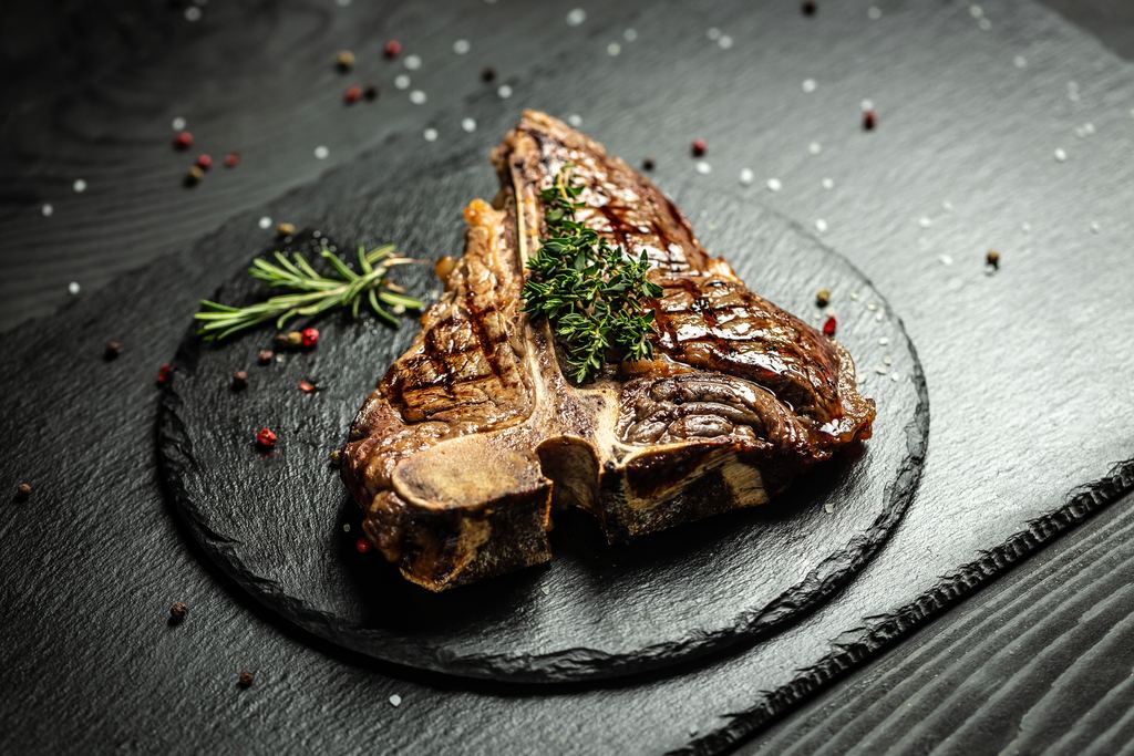 Grilled bistecca alla fiorentina, a thick T-bone steak served medium rare