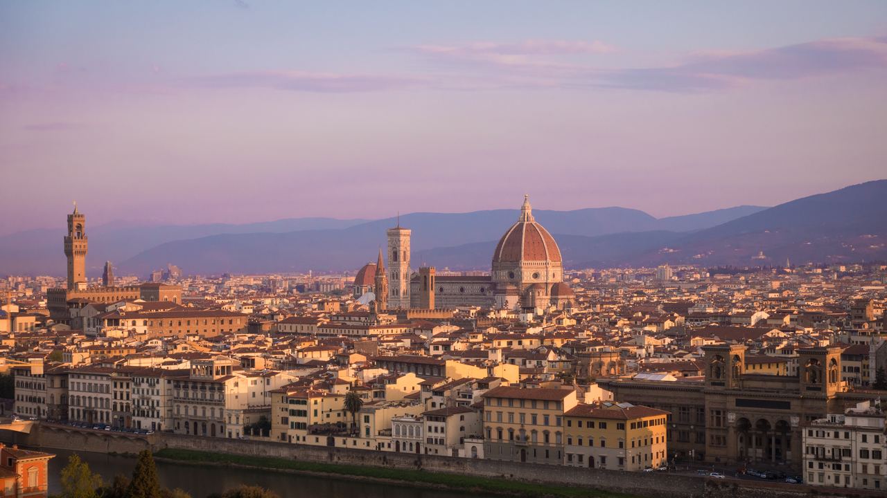 Florence skyline at sunrise seen from a hilltop viewpoint, with the Duomo dome