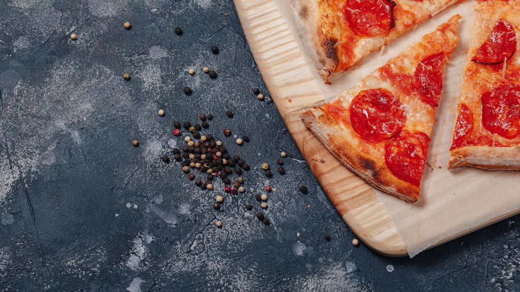 A Neapolitan margherita pizza with mozzarella and basil on a wooden board