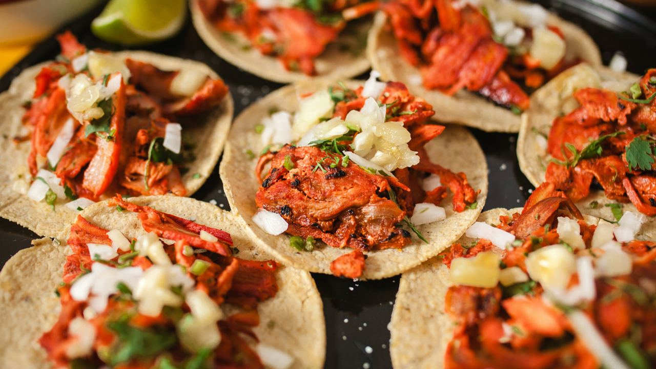 Tacos al pastor being prepared at a street food stall in Mexico City