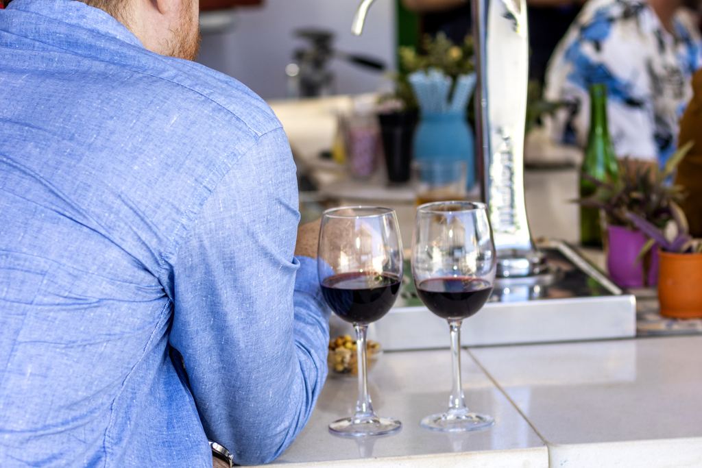 Man drinking a glass of wine at the counter of a traditional Spanish bar